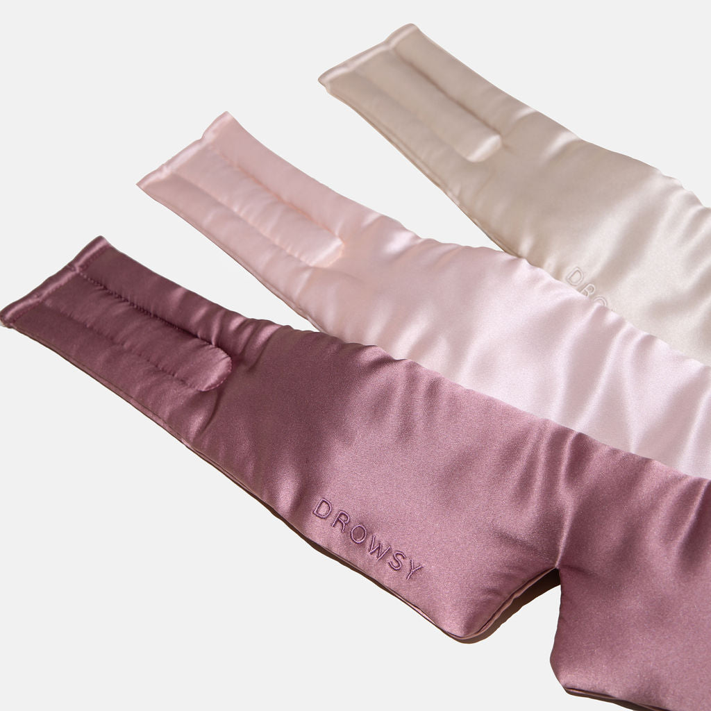 The Besties Pack features three overlapping silk sleep masks in mauve, pink, and cream on a white background. The mauve mask at the front is embroidered with "DROWSY.