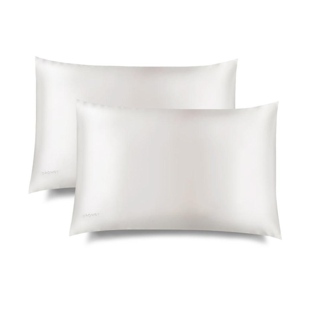 Two Akoya Pearl Silk Pillowcases feature a sleek white rectangular design with a subtle embroidered DROWSY logo in the lower left corner, displayed on a white background with a soft right shadow—an essential for hair protection and skincare.