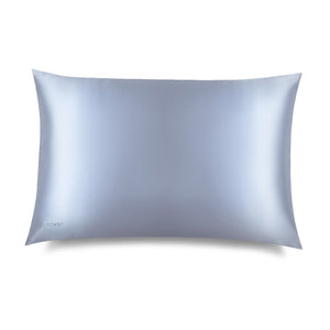 The Blue Belle Silk Pillowcase, in smooth light blue silk with a subtle sheen, lies flat on a white background. DROWSY is printed on the bottom left—ideal for hair protection and beauty routines.