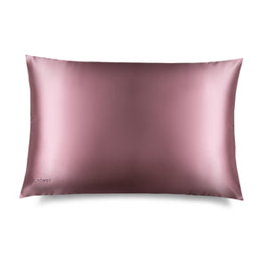 The Damask Rose Silk Pillowcase features a sleek pink rectangular design with a subtle embroidered DROWSY logo in the lower left corner, displayed on a white background with a soft right shadow—an essential for hair protection and skincare.