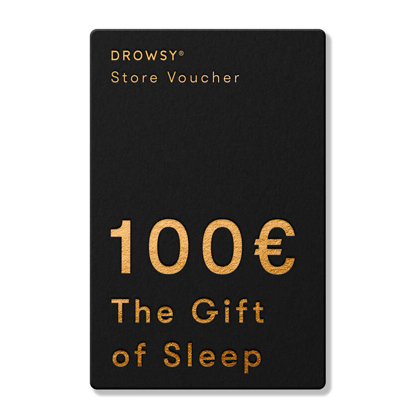 A black Sleep Gift Card with gold text reads: DROWSY Store Voucher 100€. The Gift of Sleep—perfect for treating someone special at our online store.