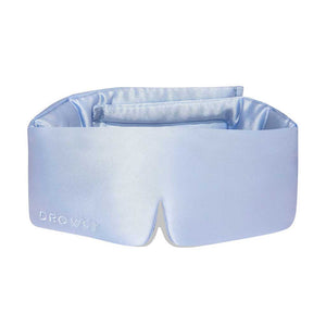 The Blue Belle is a light blue silk eye mask with DROWSY embroidered on the left, designed to enhance beauty sleep and shown against a white background.