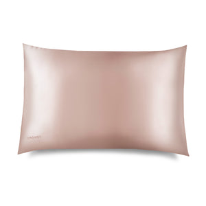 The Sunset Pink Silk Pillowcase features a light pink, smooth, shiny surface against a white background. “DROWSY” is displayed in small letters on the bottom left, highlighting its hair and skincare benefits.