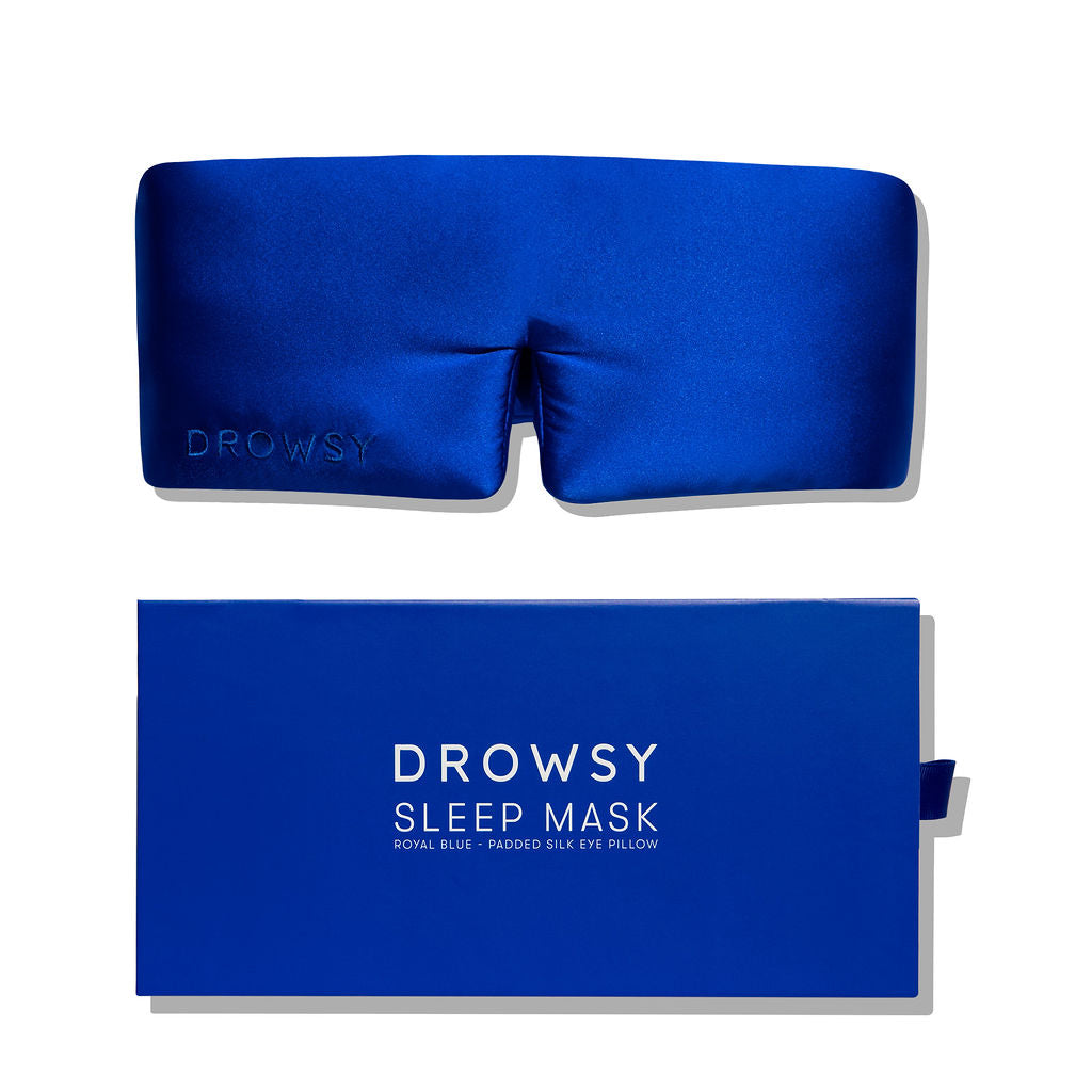 A royal blue padded silk eye mask is displayed above its matching rectangular box labeled Royal Blue in white letters.