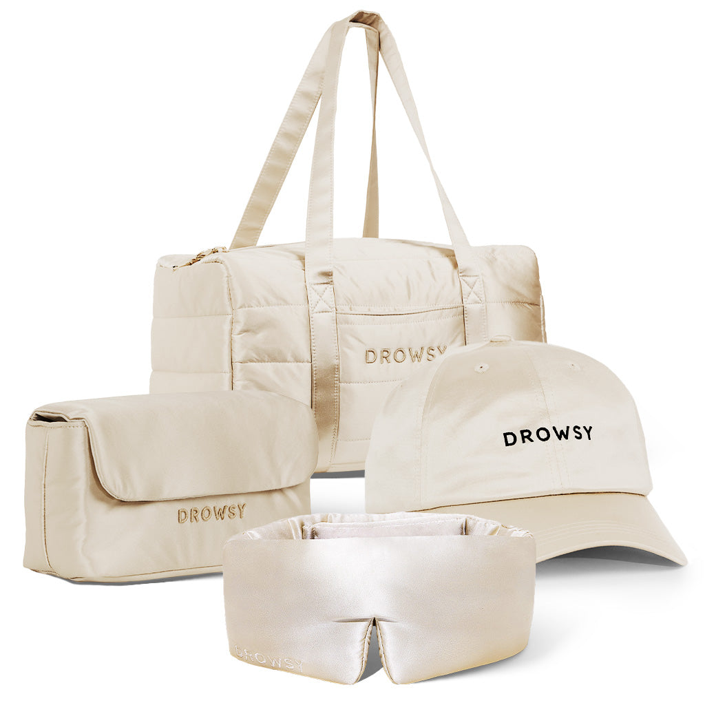 The Perfect scape bundle - Dusty Gold by drowsysleepco includes a beige duffel, toiletry bag, Drowsy-branded cap, and silk sleep mask—stylish essentials for beauty sleep wherever you go.