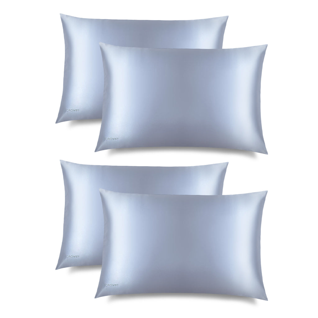 Four Blue Belle Silk Pillowcases, in smooth light blue silk with a subtle sheen, lies flat on a white background. DROWSY is printed on the bottom left—ideal for hair protection and beauty routines.