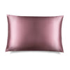 The Damask Rose Silk Pillowcase features a sleek pink rectangular design with a subtle embroidered DROWSY logo in the lower left corner, displayed on a white background with a soft right shadow—an essential for hair protection and skincare.