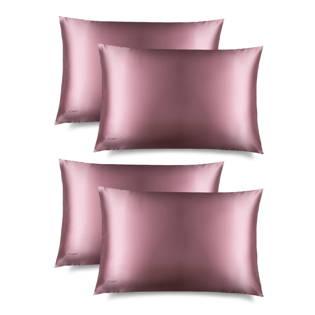 Four Damask Rose Silk Pillowcases feature a sleek pink rectangular design with a subtle embroidered DROWSY logo in the lower left corner, displayed on a white background with a soft right shadow—an essential for hair protection and skincare.
