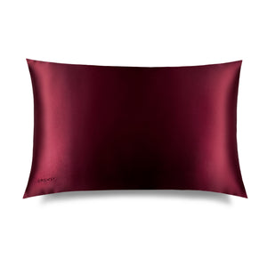 The La Vie En Rouge Silk Pillowcase, in deep burgundy with a subtle sheen, is rectangular and hair-protecting, featuring "DROWSY" embroidered in one corner, shown against a plain white background.