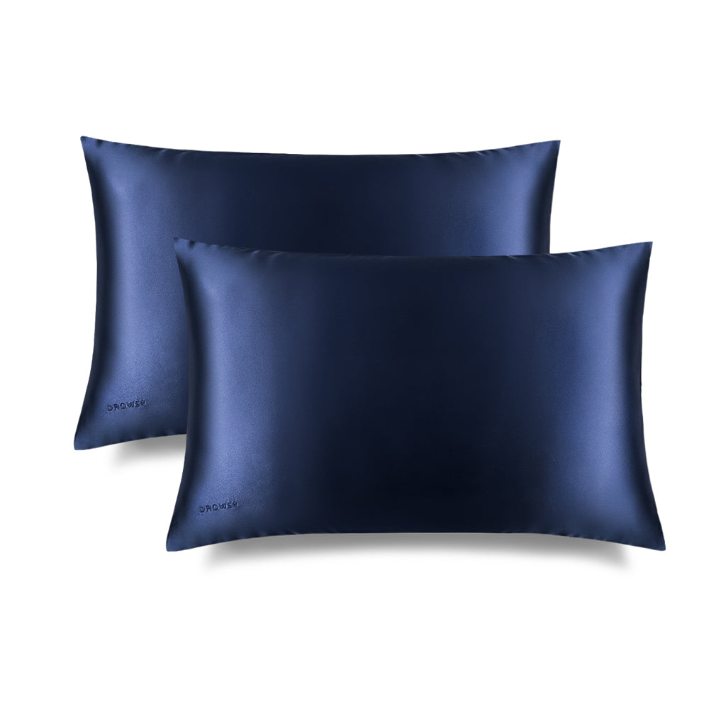 Two Midnight Blue Silk Pillowcases feature a sleek blue rectangular design with a subtle embroidered DROWSY logo in the lower left corner, displayed on a white background with a soft right shadow—an essential for hair protection and skincare.