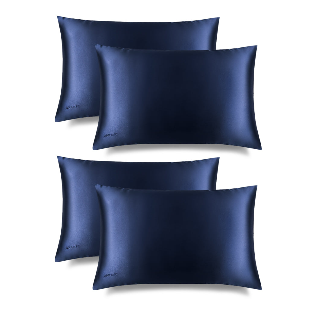 Four Midnight Blue Silk Pillowcases feature a sleek blue rectangular design with a subtle embroidered DROWSY logo in the lower left corner, displayed on a white background with a soft right shadow—an essential for hair protection and skincare.