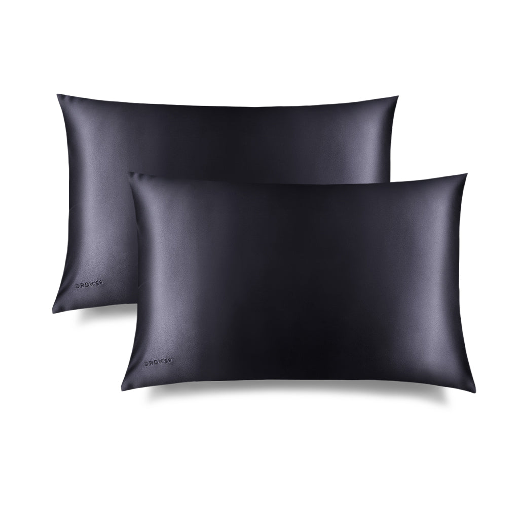 Two Moonlight Shadow Silk Pillowcases, rectangular and smooth in black silk with DROWSY embroidered in the lower left corner, is shown on a white background with a subtle right shadow—ideal for skincare and hair protection.