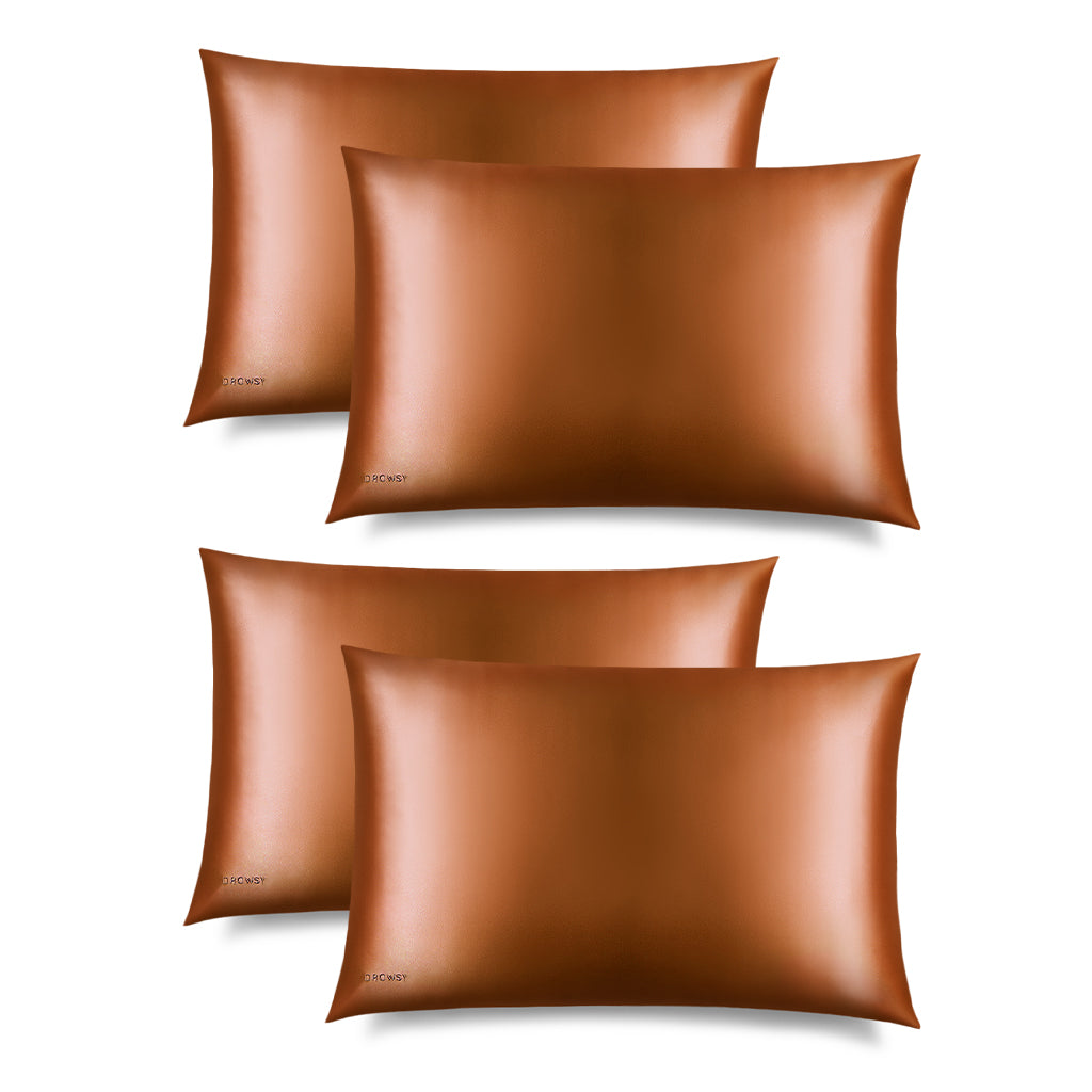 Four Pumpkin Spice Silk Pillowcases, in a shiny bronze hue, is displayed on a white background with a “DROWSY” logo in the corner—an essential for skincare and beauty, perfect for protecting your hair.