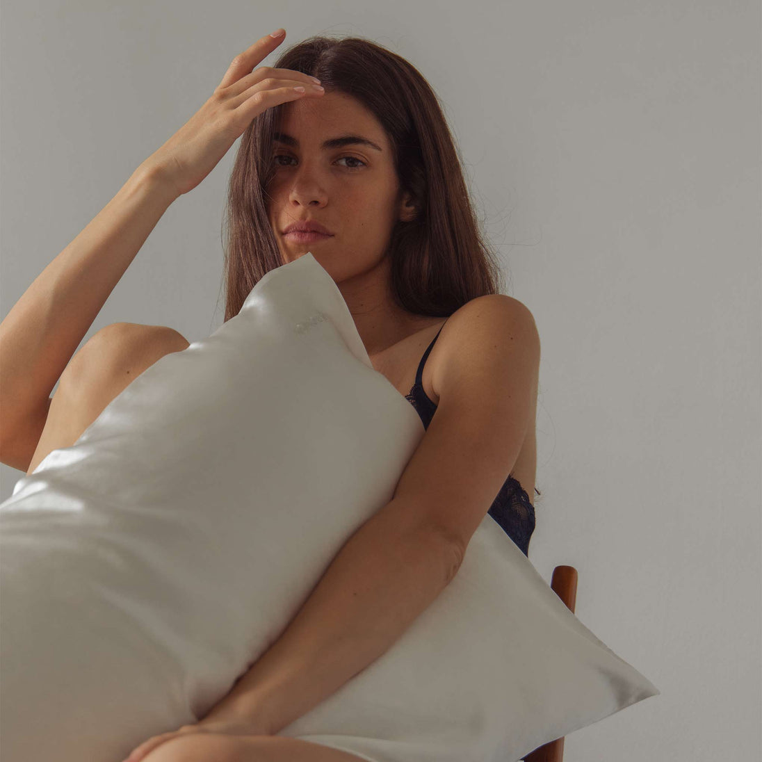 Model holding white Drowsy silk pillowcase
