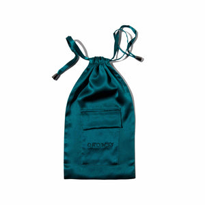 The Green Sapphire Silk Carry Pouch, made from teal satin mulberry silk with DROWSY embroidered on the front pocket, is perfect for storing your silk sleep mask and is shown on a white background.