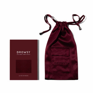 A luxury mulberry silk pouch in burgundy with a drawstring, named La Vie En Rouge Silk Carry Pouch, rests beside its elegant matching box—perfect for storing your favorite silk sleep mask.