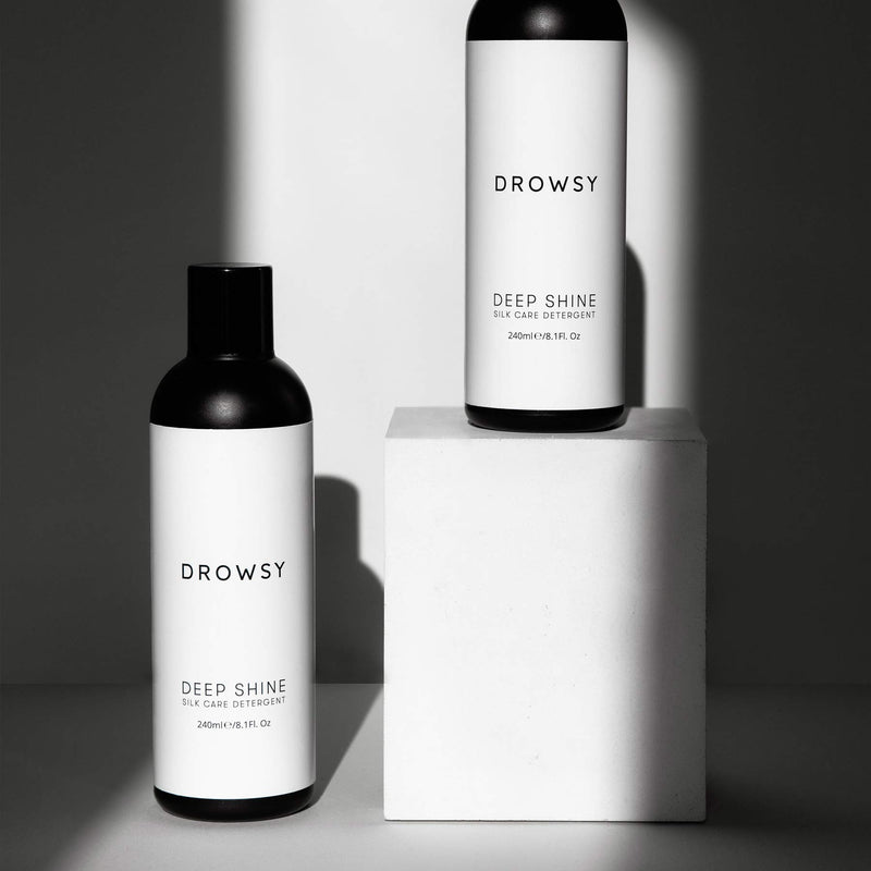 Two Drowsy deep shine silk detergent, one on a box, black and white photo with shadow