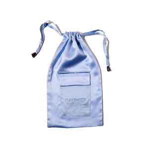 The Blue Belle Silk Carry Pouch is a light blue satin pouch with a small front pocket, DROWSY embroidered on it, and a secure drawstring closure, shown against a white background.