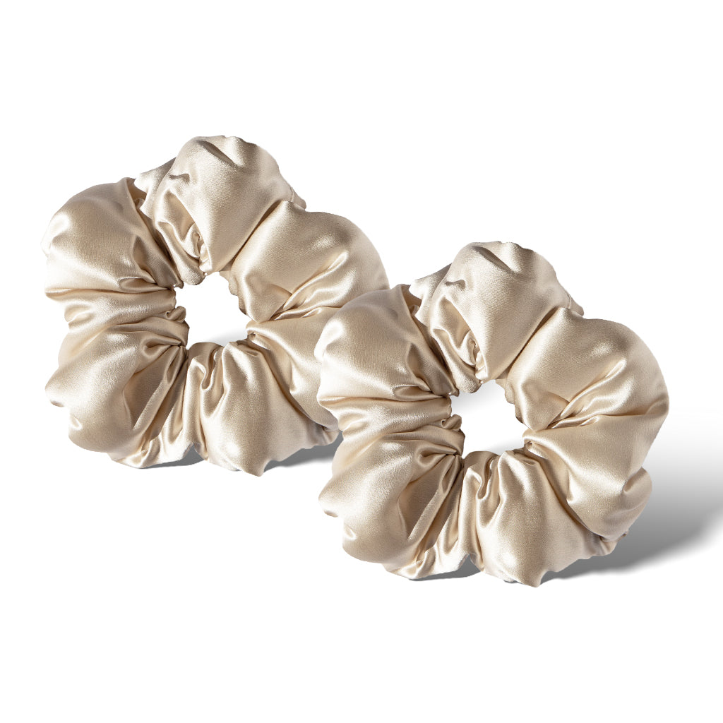 Two Dusty Gold - Padded Scrunchies are displayed side by side on a white background, showcasing their light beige satin shine, soft gathered texture, and plush design—ideal for gentle hair styling or as a luxurious sleep accessory.