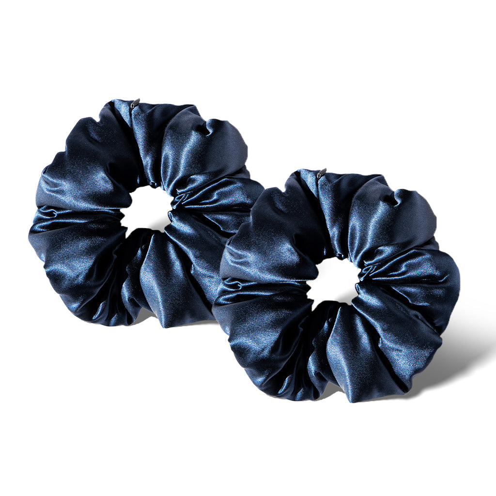 Two padded "Midnight Blue" satin scrunchies are displayed side by side on a white background, highlighting their soft, gathered texture and chic circular shape—a stylish accessory for night or day.