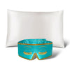 The Perfect Skin Bundle Breakfast at Drowsy by drowsysleepco showcases a white silk pillowcase and a turquoise sleep mask with gold embroidered eyelashes, set against a white background—ideal for elevating your beauty sleep.