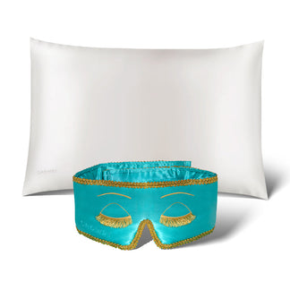 The Perfect Skin Bundle Breakfast at Drowsy by drowsysleepco showcases a white silk pillowcase and a turquoise sleep mask with gold embroidered eyelashes, set against a white background—ideal for elevating your beauty sleep.