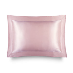 The Hyalo Pillowcase - Petal Pink by us.drowsysleepco is featured against a white background. This light pink silk pillowcase showcases a smooth texture and bordered edge, making it ideal for overnight hydration. It helps your skin retain moisture while you sleep—offering benefits similar to those of hyaluronic acid.